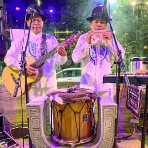 Zwei Männer spielen Instrumente auf einer Bühne in der Unterkunft Chakana Hotel Boutique Mariscal in Quito