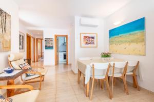 a dining room and living room with a table and chairs at Apartamento Olot in Pollença