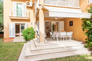 a patio with a table and chairs in front of a house at Apartamento Olot in Pollença