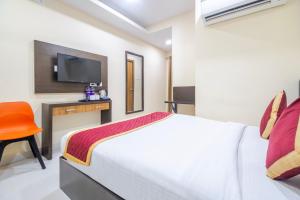 a bedroom with a bed and a desk and a television at Lemonridge Hotels Kukatpally in Hyderabad