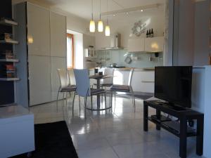een woonkamer met een televisie en een tafel met stoelen bij Villa Oreste in Salerno
