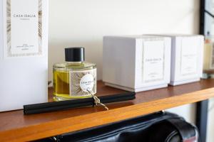 a bottle of perfume on a wooden shelf with other items at Casa Idalia Boutique Hotel in Comporta