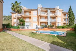 an apartment building with a swimming pool in front of it at Apartamento Olot in Pollença