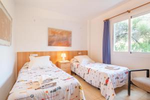 a bedroom with two beds and a window at Apartamento Olot in Pollença +16 photos