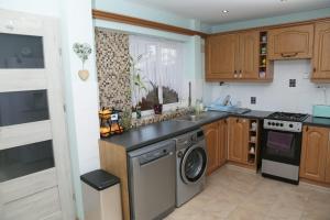a kitchen with a washing machine and a sink at Lux House in Peterborough