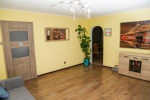 ein Wohnzimmer mit gelben Wänden, einer Tür und Holzböden in der Unterkunft Lux House in Peterborough