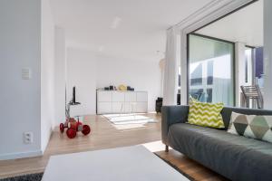 een woonkamer met een bank en een tafel bij Lichtrijk & ruim app aan zee met zonneterras - 6p in Wenduine