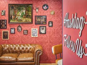 sala de estar con sofá y pared roja en Ibis Styles Paris Gare de l'Est Magenta en París