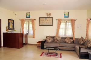 a living room with a couch and two windows at Franc Villa - Kothagiri in Kotagiri
