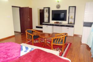 a living room with a table and two chairs at Franc Villa - Kothagiri in Kotagiri