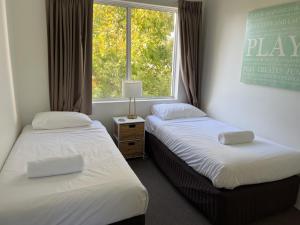 two beds in a room with a window at Abby’s Beach Villa in Broadwater +51 photos