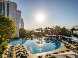 a large swimming pool with lounge chairs and umbrellas at Swissotel The Bosphorus Istanbul in Istanbul