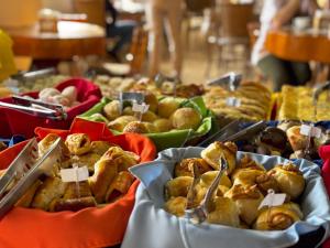 una mesa con diferentes tipos de comida en bandejas en Pousada Kaliman Luxo, en Campos do Jordão