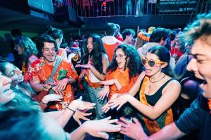 un grupo de personas de pie en una multitud en The ESN Kingsday Campsite, en Ámsterdam
