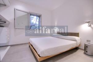 a white bedroom with a bed and a window at Il Poggettino, esclusiva villetta a picco sul mare! by Alfareal in Castiglione della Pescaia