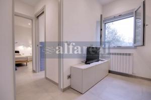 a living room with a tv and a window at Il Poggettino, esclusiva villetta a picco sul mare! by Alfareal in Castiglione della Pescaia