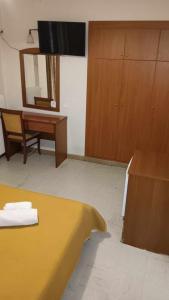 Habitación con cama, espejo y escritorio. en Hotel Liberty, en Mesolongi