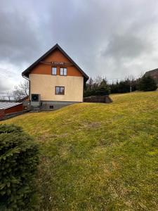 a house on top of a grassy hill at Cestář in Loučná pod Klínovcem