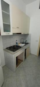 a kitchen with a stove and white cabinets at Casa Gaia in Palermo