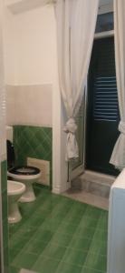 a bathroom with a toilet and a green floor at Casa Gaia in Palermo