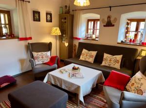 uma sala de estar com um sofá, cadeiras e uma mesa em ALCHYMISTA MINING HOUSE em Spania Dolina
