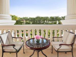 einen Balkon mit einem Tisch und einer Blumenvase darauf in der Unterkunft Raffles The Palm in Dubai