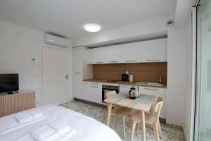 a bedroom with a bed and a table and a kitchen at New studio aperçu mer Monaco border in Beausoleil