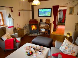a living room with a fireplace and a television at ALCHYMISTA MINING HOUSE in Špania Dolina
