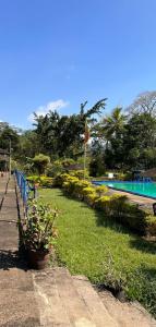 un parque con piscina, bandera y plantas en Kothmale Holiday Resort en Gampola