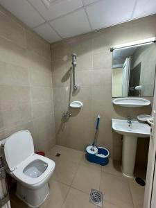 a bathroom with a toilet and a sink at Palm Inn Hostel 2024 in Dubai