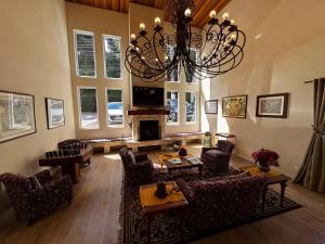 カンポス・ド・ジョルドンにあるPousada Kaliman Luxoのリビングルーム(シャンデリア、ソファ、椅子付)
