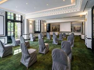 a conference room with chairs and a projection screen at Aigle Noir Fontainebleau MGallery in Fontainebleau