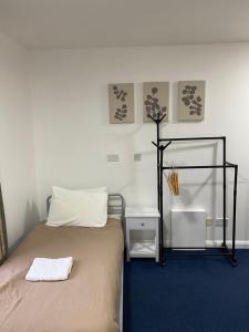 ein Schlafzimmer mit einem Bett mit einem Spiegel und einem Nachttisch in der Unterkunft Pax Lodge in London