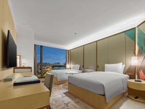 Cette chambre comprend deux lits et une télévision. dans l'établissement Doubletree By Hilton Nanning Wuxiang, à Nanning
