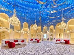 ドーハにあるRaffles Dohaのシャンデリアと青い天井が特徴の広い客室です。