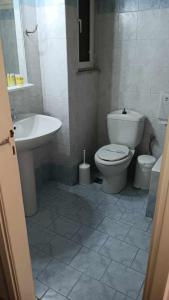 łazienka z toaletą i umywalką w obiekcie Hotel Liberty w mieście Missolungi