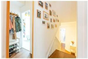 un couloir avec un escalier avec des photos sur le mur dans l'établissement Stylish, 2 Bed Apartment, Muswell Hill, à Londres