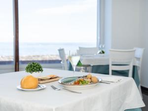 a table with a plate of food and a glass of wine at Balneario Pozo de la Salud in Sabinosa