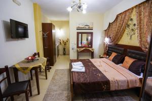 a bedroom with a bed and a table and a television at Relax pozar in Kato Loutraki