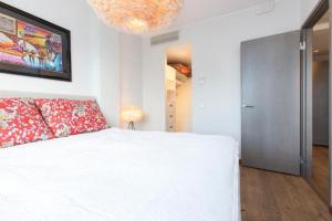 a bedroom with a white bed and a chandelier at Cozy city apartment in Tallinn