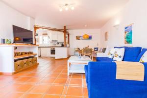 a living room with a blue couch and a kitchen at Apartment Chateau Morro 4 in Morro del Jable