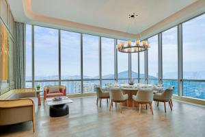 a dining room with a table and chairs and large windows at DoubleTree by Hilton Zhuhai Hengqin in Zhuhai