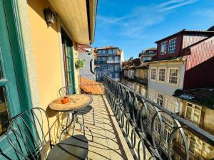 einen Balkon mit einem Tisch und Stühlen auf einem Gebäude in der Unterkunft Amazing Flat Sao Bento in Porto