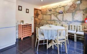 einen Tisch und Stühle in einem Zimmer mit einer Steinmauer in der Unterkunft Amazing Flat Sao Bento in Porto