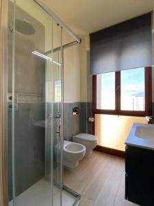 a bathroom with a glass shower and a toilet at Luminoso appartamento Cisanello in Pisa