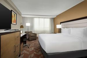 een hotelkamer met een groot wit bed en een bureau bij Doubletree By Hilton Greensboro Airport in Greensboro