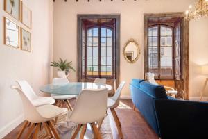 ラスパルマス・デ・グランカナリアにあるApto Pepita - Casa San Marcialのダイニングルーム(ガラステーブル、白い椅子付)