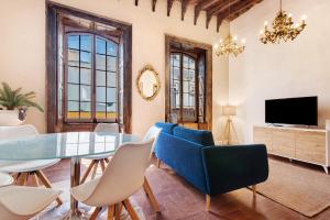 a living room with a table and chairs and a television at Apto Pepita - Casa San Marcial in Triana