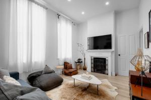 a living room with a couch and a tv at Your home on Smith St Collingwood (With Parking) in Melbourne