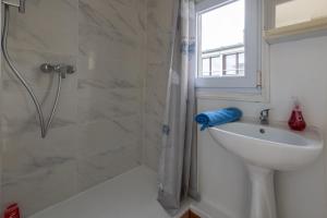 Un baño blanco con ducha y lavabo. en Les Reflets de la Mer 5 - A moins d'1 km de la mer, en Le Tréport